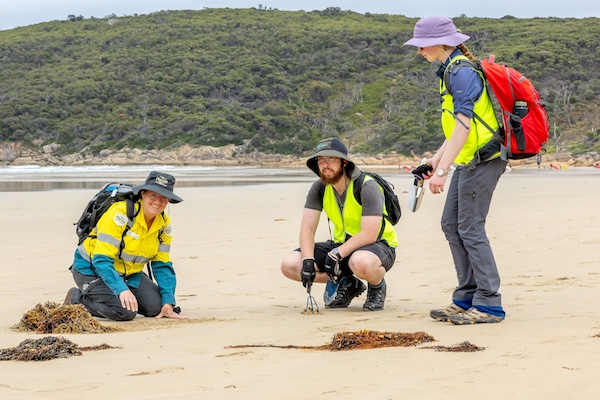 Rangers with community members on a beach